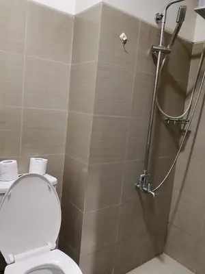a bathroom with a shower with a toilet and a shower at Jaina Staycation in Manila