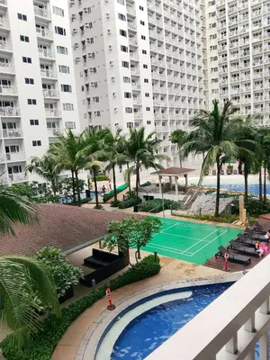 a view of a tennis court and palm trees and buildings at Jaina Staycation in Manila