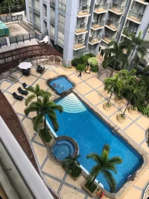 an overhead view of a large swimming pool with palm trees at Sun Property in Manila