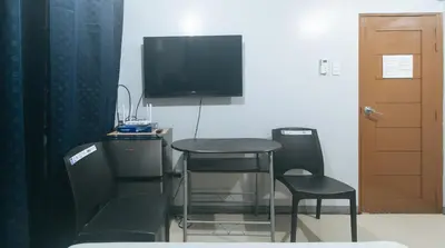 a room with a table and two chairs and a television at VCloud Hills Boarding House Near NAIA Terminal in Manila