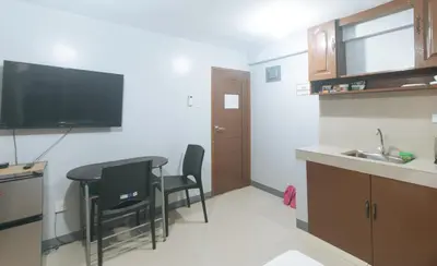 a small kitchen with a table and chairs and a sink at VCloud Hills Boarding House Near NAIA Terminal in Manila