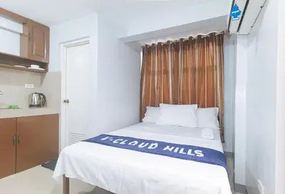 a small bedroom with a bed with a window at VCloud Hills Boarding House Near NAIA Terminal in Manila