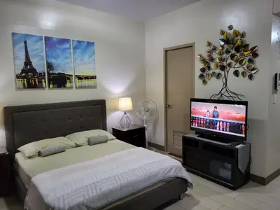 a bedroom with a bed and a flat screen tv at Liana's Condo Newport City in Manila