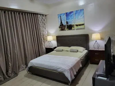 a bedroom with a bed and a television in it at Liana's Condo Newport City in Manila