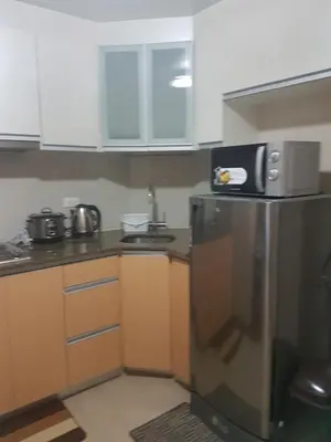 a kitchen with a microwave on top of a refrigerator at Liana's Condo Newport City in Manila