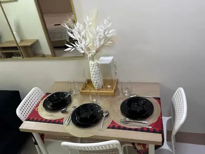 a table with plates and glasses and a vase of flowers at jastmypads and staycation in Manila