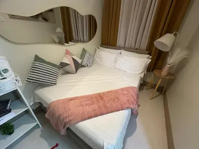 a bedroom with a bed with a mirror on the wall at jastmypads and staycation in Manila