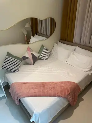 a large white bed with pillows on top of it at jastmypads and staycation in Manila