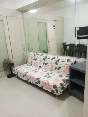 a living room with a couch with a flower pattern at Tower F Sea Residence in Manila