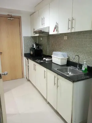 a kitchen with white cabinets and a sink at Tower F Sea Residence in Manila
