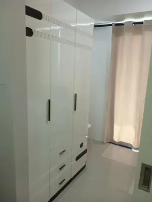 a white cabinet in a room with a window at Tower F Sea Residence in Manila