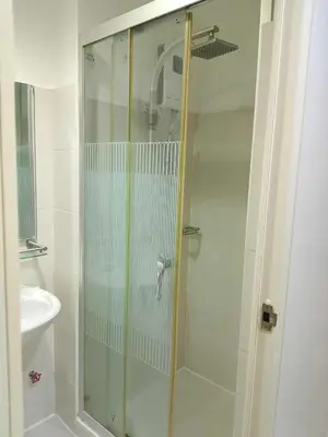 a shower with a glass door in a bathroom at Tower F Sea Residence in Manila