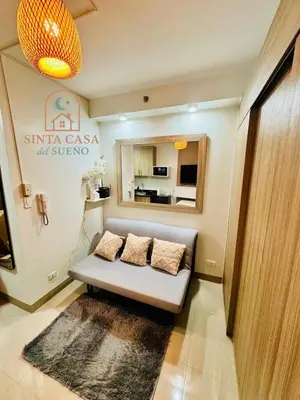 a room with a couch with two pillows on it at Sinta Casa del Sueno MOA Stay with Pool and Wi-fi in Manila