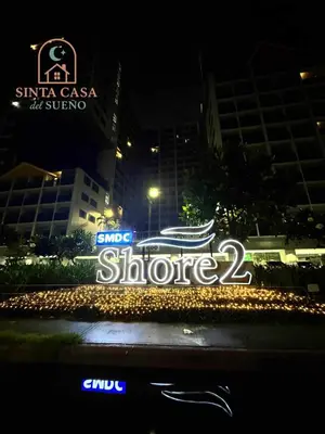 a sign for a store in a city at night at Sinta Casa del Sueno MOA Stay with Pool and Wi-fi in Manila