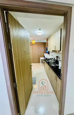 a kitchen with a door open to a kitchen with a counter at Sinta Casa del Sueno MOA Stay with Pool and Wi-fi in Manila