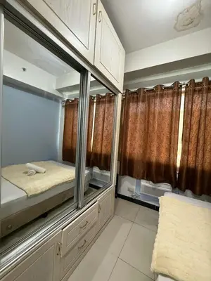 a small room with a large mirror and some curtains at Sea Residences Golden Empire in Manila