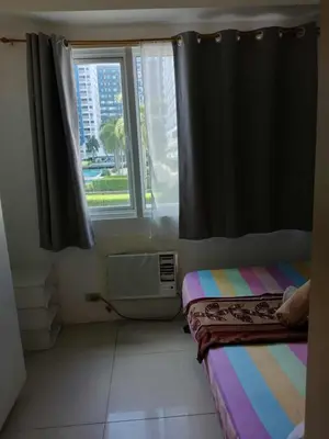 a room with a window and a bed and a sink at Sea Residences Golden Empire in Manila