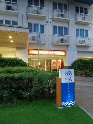 a large building with a sign in front of it at Sea Residences Golden Empire in Manila
