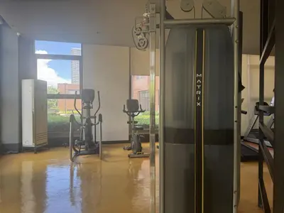 a gym with treadmills and machines in a room at Levi & Moon's Manila Bay in Manila