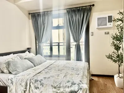 a bedroom with a bed and a large window at Levi & Moon's Manila Bay in Manila