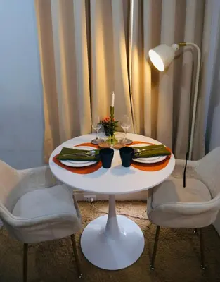 a white table with two chairs and a candle on it at Modern Retro Stay near NAIA 3 in Manila