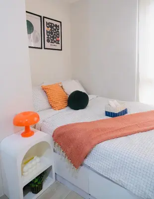 a bedroom with a bed with an orange stool on it at Modern Retro Stay near NAIA 3 in Manila