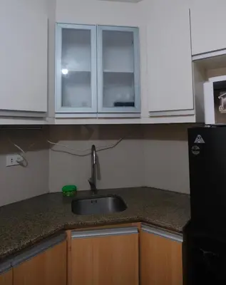 a kitchen with a sink and white cabinets at Modern Retro Stay near NAIA 3 in Manila