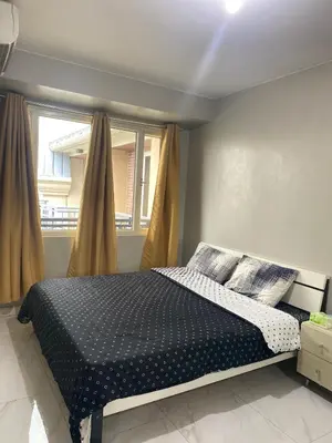 a bedroom with a bed and a window at Monarch Park Suites WS in Manila