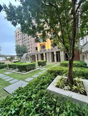 a courtyard with a tree and a building at Monarch Park Suites WS in Manila