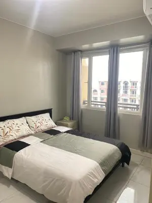 a bedroom with a large bed and a window at Monarch Park Suites WS in Manila