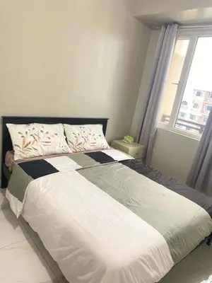 a large bed in a bedroom with a window at Monarch Park Suites WS in Manila