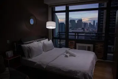 a bedroom with a bed with a view of a city at E-Studio,Best Sunset Pool,Luxury,Hotel Style in Manila