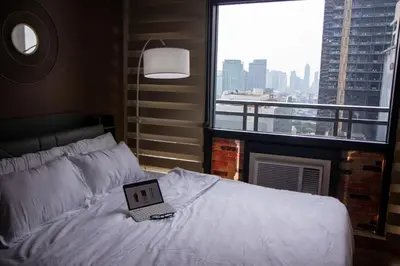 a bedroom with a bed with a laptop on it at E-Studio,Best Sunset Pool,Luxury,Hotel Style in Manila