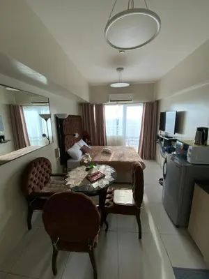 a bedroom with a bed and a table and chairs at Breeze Staycation by Charmed in Sampong