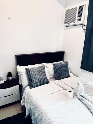 a bedroom with a bed with white sheets and pillows at High Rise 2br In the Makati Skyline with KTV Pools in Manila