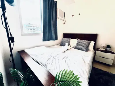 a large bed in a bedroom with a window at High Rise 2br In the Makati Skyline with KTV Pools in Manila