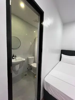 a bathroom with a bed and a sink and a toilet at 20 Boeing Apt in Manila
