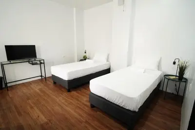 a room with two beds and a television in it at 20 Boeing Apt in Manila