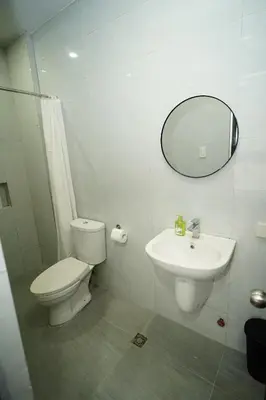 a bathroom with a toilet and a sink and a mirror at 20 Boeing Apt in Manila