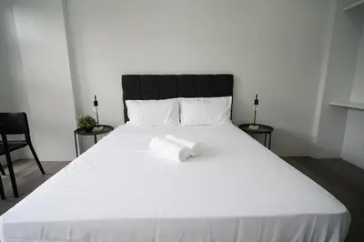a large white bed with a pile of towels on it at 20 Boeing Apt in Manila