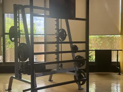 a gym with a squat rack in a room with windows at Levi & Moon Relax and Chill in Manila