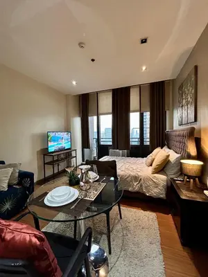 a living room with a bed and a table at Condo Living - Pool, Balcony, Gym, Fast WiFi in Manila