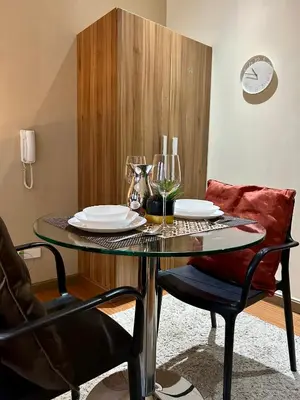 a dining room table with plates and wine glasses at Condo Living - Pool, Balcony, Gym, Fast WiFi in Manila
