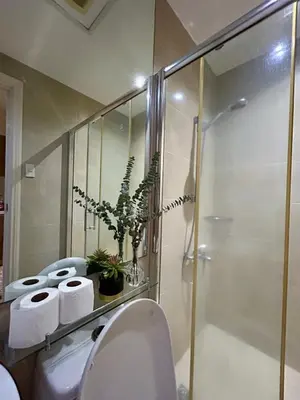 a bathroom with a toilet and a glass shower at Condo Living - Pool, Balcony, Gym, Fast WiFi in Manila