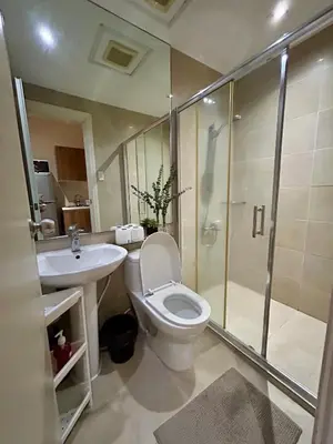 a bathroom with a toilet and a shower and a sink at Condo Living - Pool, Balcony, Gym, Fast WiFi in Manila