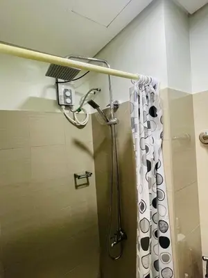 a shower in a bathroom with a shower curtain at Shore Residences Moa Pasay in Manila