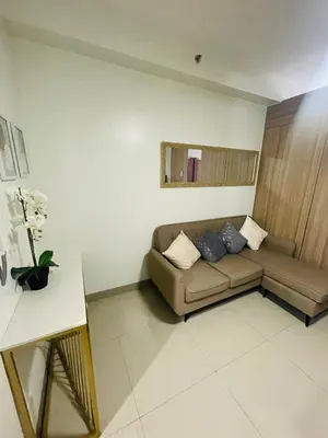 a living room with a couch and a table at Shore Residences Moa Pasay in Manila