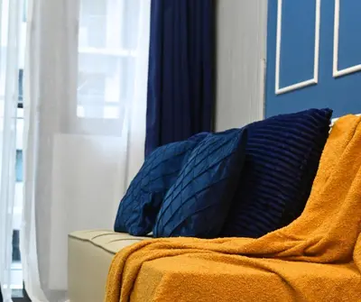 a blue pillow sitting on a couch next to a window at Chic & Cozy Urban Stay in Manila