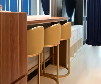 a bar with three stools at a kitchen counter at Chic & Cozy Urban Stay in Manila