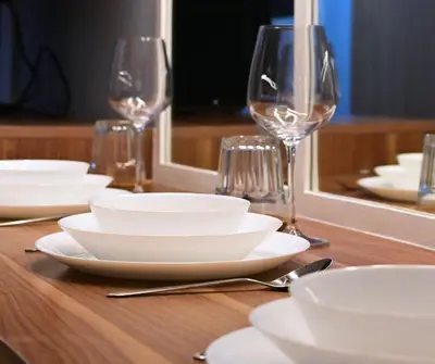 a table with white plates and wine glasses at Chic & Cozy Urban Stay in Manila